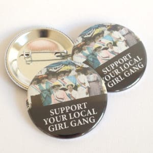 Kvinnohistoriska pins med texten "Support your local girl gang" och en bild av en grupp amerikanska suffragetter